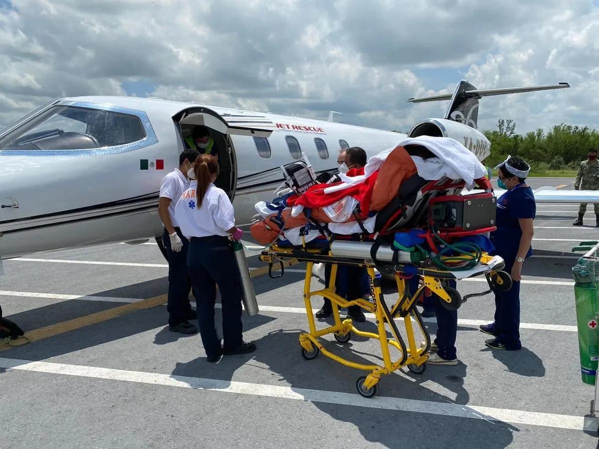 Medical team attending a patient next to an ambulance plane