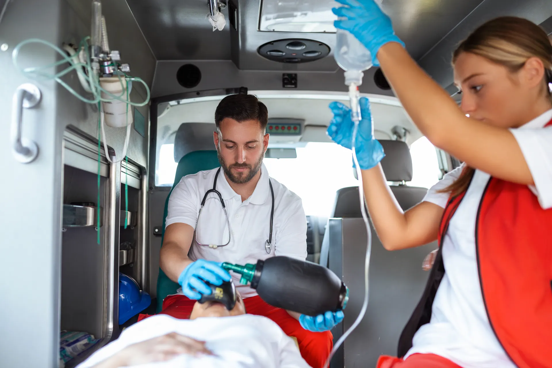 Emergency services workers caring for a patient inside an ambulance